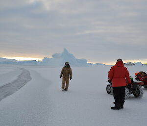 Expeditioners with quad bikes stop at lead in sea ice