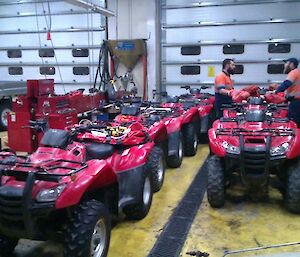Two expeditioner standing alongside fleet of quad bikes