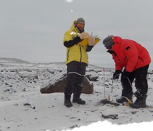 Two expeditioners measuring depth of water level