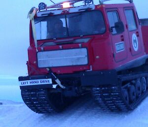 Red Hägglunds going down a steep rise