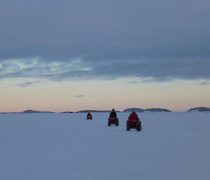 Three quad riders following in single file on sea ice