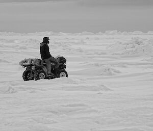 Expeditioner riding quad bike picking an easy route through some uneven ice