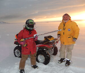 Two expeditioners prepare to drill sea ice