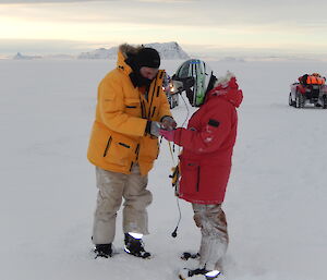 Two expeditioner unravelling a tape measure