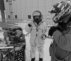 Two expeditioners standing alongide quad bikes