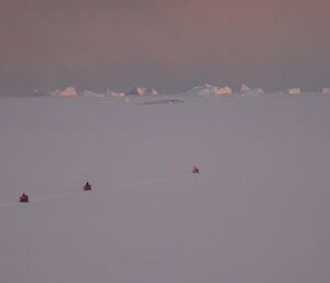 Three quads single file on the sea ice