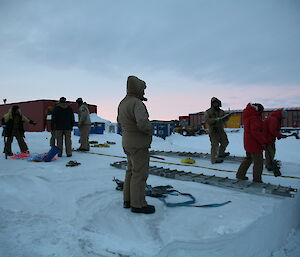 Numerous people involved in setting up gear to recover hagglund