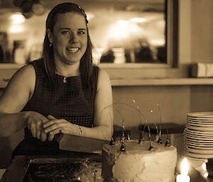Black and white photo of expeditioner cutting her cake