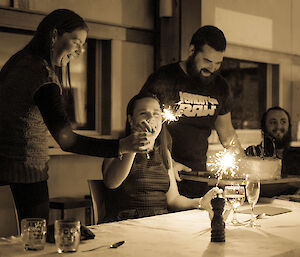 Black and white photo of expeditioners presenting a birthday cake