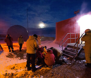Group of expeditioners attending to patient outside building