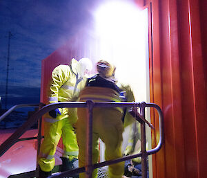 Two firefighters carrying a dummy as they exit a building