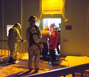 Large team of people carrying patient on stretcher into medical facilities