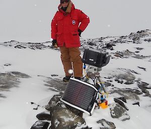 Expeditioner standing next to camera euqipment and solar panels