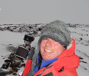 Expeditioner taking a photo of himself with camera monitoring equipment in the background