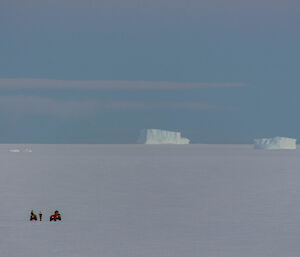 Long distance photo of quads on the sea ice off station