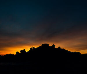 Stunning bright yellow and orange sunrise with rocks in background