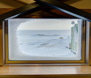 View of the snow and buildings through a window