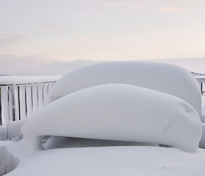 Outdoor tables and chairs hidden under half a metre of snow