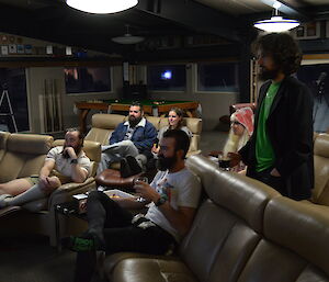 Group of expeditioners facing a TV screen watching a movie