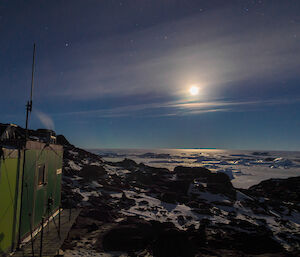 Full moon in the background with field hut in full view