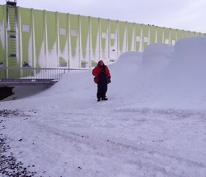 Expeditioner standing next to a large snow drift