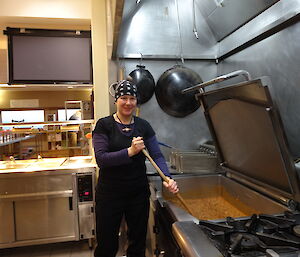 Chef in the kitchen stirring a stew in the brat pan