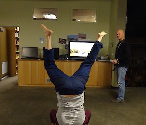 Expeditioner standing on his head in a yoga class