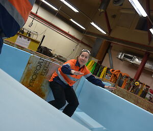 Expeditioner squatting down inside the shipping container