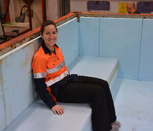 Expeditioner sitting on bench made of insulation inside shipping container