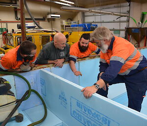Four expeditioners looking into the man made hot tub