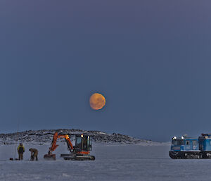 Haggund and excavator on the sea ice expeditioners looking for a good area to but a hole in the ice