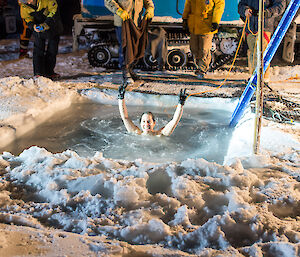 Expeditioner raising her arms above her head in the icy cold water