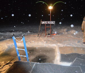 Ice filled swimming pool through the sea ice Davis pool sign in the background