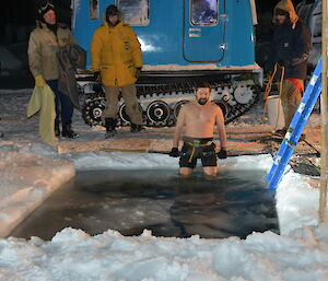 Expeditioner lowers himself into the icy water