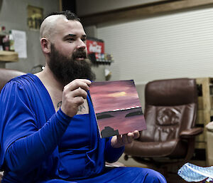 Expeditioner holding a small painting