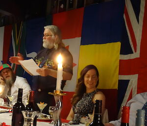 Expeditioner standing making a speech to everyone seated at the formal dinner table