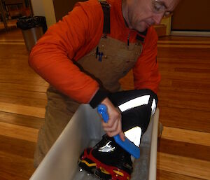 Expeditioner cleaning his boots in a tub