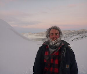 Expeditioner with ice and snow in his beard with lake in background