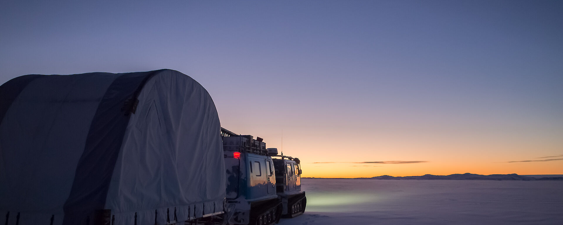 hagglund towing a tent on a sled on the sea ice