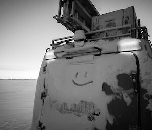 The back of the Hägglunds with a smiley face drawn on the snow covered back window