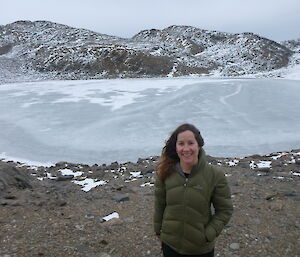 Expeditioner in the field with frozen lake in background