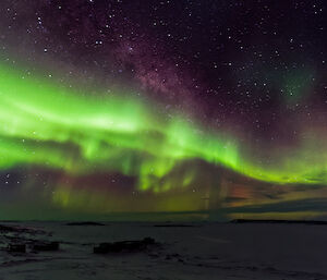 Bright green aurora above station buildings