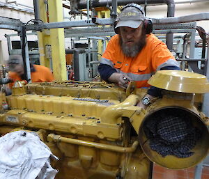 Expeditioner working on a large yellow engine