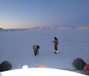 Two expeditioners with sea ice drills on the sea ice