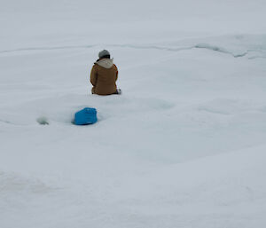 Expeditioner resting on the frozen lake enjoying the views