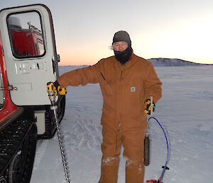 Expeditioner holding a long thin buoy on a cable