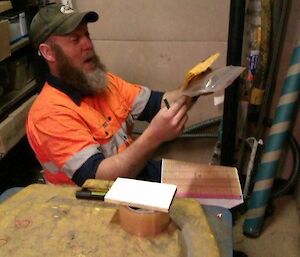 Expeditioner sitting on the floor with shelves of stock in front of him