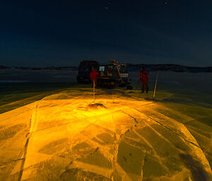 Yellow lights under a frozen lake