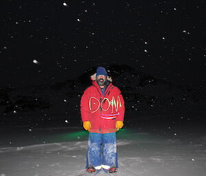 Expeditioner standing on sea ice at night