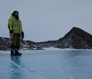 Expeditioner standing on a smooth frozen lake